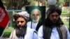 Former Taliban prisoners stand in front of a portrait of Afghan President Ashraf Ghani as they attend a ceremony at the governor's office after being released, in Herat on May 26.