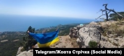 Сине-желтый флаг на горной вершине в Крыму. Одна из акций активистов движения «Желтая лента»