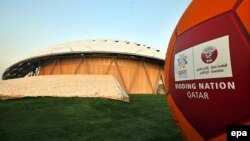 Катар - Мяч с логотипом МЧ-2022 на фоне построенного по современным технологиям стадиона в Дохе