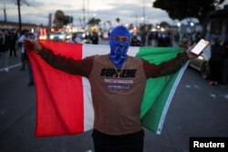 Пратэстовец з мэксыканскім сьцягам у горадзе Парамаўнт 7 чэрвеня 2025 году