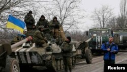 Член моніторингової місії ОБСЄ біля українських військовослужбовців. Село Парасковіївка, поблизу Артемівська, 26 лютого 2015 року