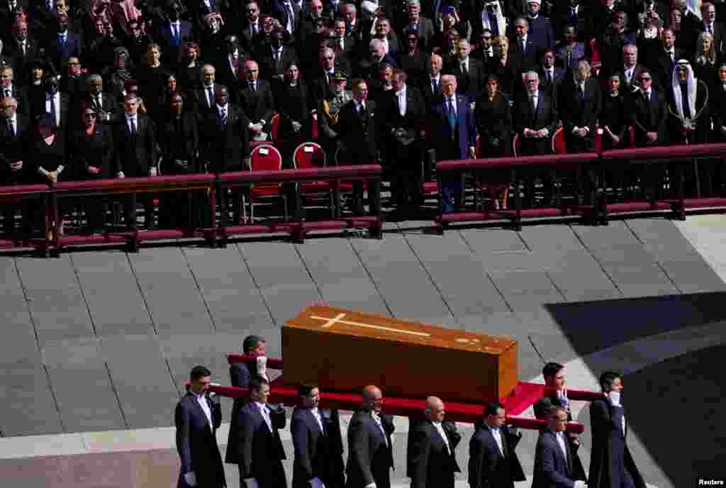 Президент США Дональд Трамп, президент Польши Анджей Дуда, президент Финляндии Александр Стубб и король Испании Филипп стоят, пока носильщики несут гроб с телом папы римского Франциска во время мессы по случаю его похорон на площади Святого Петра в Ватикане, 26 апреля 2025 года. REUTERS/Nathan Howard