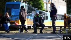 Снимката е от една от демонстративните акции на служители в градския транспорт в София по време на блокадата в средата на май. Работещи седят пред спрял трамвай в трамвайното депо "Банишора". 