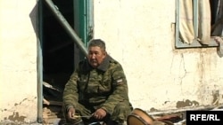 Офицер министерства по чрезвычайным ситуациям сидит у порога разрушенного от наводнения дома. Кызылагаш, 15 марта 2010 года.  