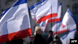 Симферополдуктар Крымдын желеги менен шаардын Ленин аянтында, 15.03.2014.