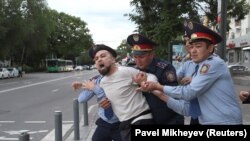 Казак полициясы Алматыдагы нааразылык акцияларынын катышуучусун кармап кетип жаткан учуру. 12-июнь, 2019-жыл. 