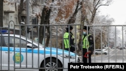 Сотрудники полиции у металлической ограды рядом с местом проведения одобренной властями акции в Алматы. Иллюстративное фото.