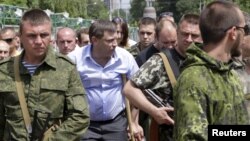 У центрі в цивільному Олександр Захарченко, ватажок угруповання «ДНР», що визнане в Україні терористичним. Донецьк, 15 червня 2015 року