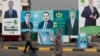 People walk past electoral campaign posters ahead of Iraq's parliamentary elections in central Baghdad on November 6.