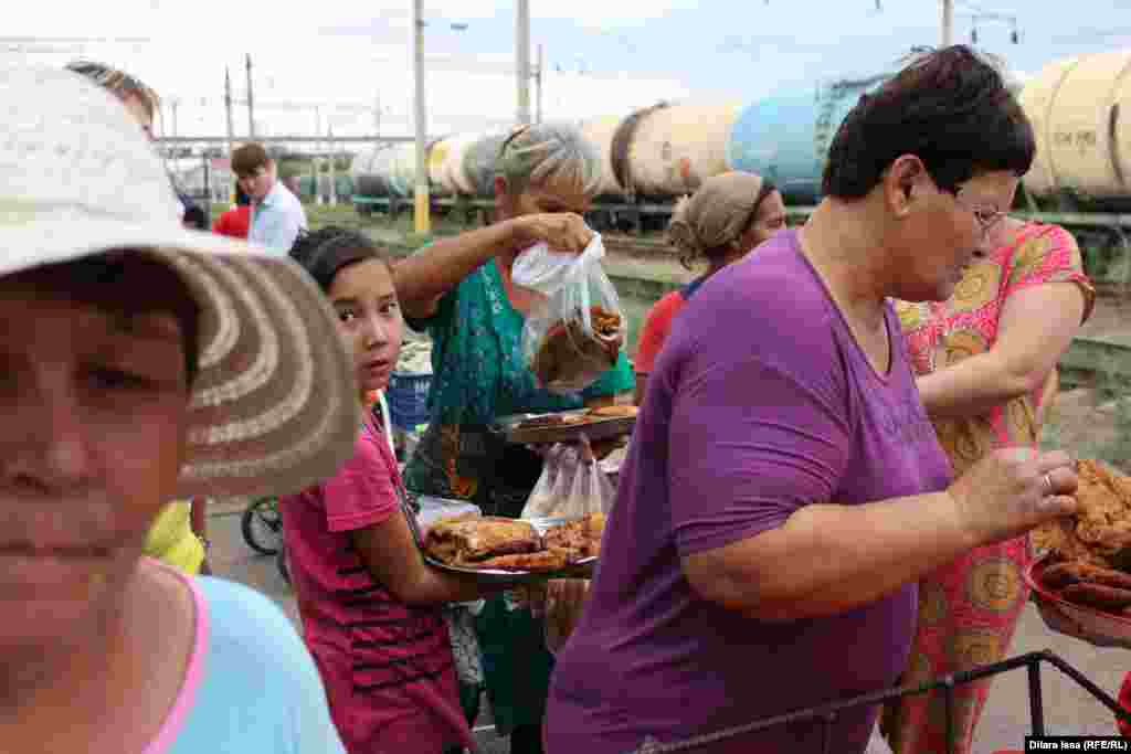 Пассажиры во время стоянки поезда на станции Чу покупают у местных жителей еду.