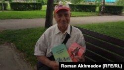 Виктор Куклин кітаптарын көрсетіп тұр. Алматы, 23 мамыр 2017 жыл.