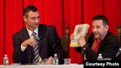 Викладач української мови Колумбійського університету Юрій Шевчук дарує політикові Віталію Кличкові нещодавно опублікований у нью-йоркському видавництві Hippocrene Books підручник «Українська для початківців» (Ukrainian for Beginners) під час зустрічі українського політика зі студентами та викладачами Колумбійського університету в жовтні 2011 року)