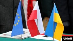 Прапори України, Польщі та ЄС під час закладання символічної капсули з інформацією про початок будівництва у Львові Центру польської культури та європейського діалогу – Польського дому. Львів, 6 листопада 2015 року