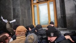 Поліцейські знімають плакат зі стіни Офісу президента