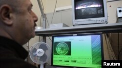 یکی از کارکنان آژانس بین‌المللی انرژی اتمی در حال بررسی نرم‌افزارهای آژانس.