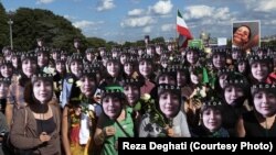 تجمع معترضان به قتل ندا آقاسلطان با تصاویری از او بر چهره‌های خود؛ پاریس، ۲۰۰۹، عکس از رضا دقتی