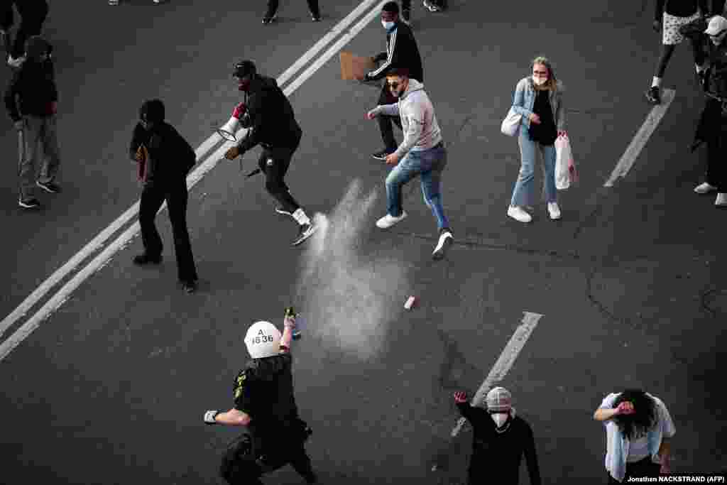 Поліція використовує перцевий спрей проти протестувальників під час демонстрації Black Lives Matter у Стокгольмі. Протест виник на знак солідарності з протестами, що вирують у США через смерть афроамериканця Джорджа Флойда. Колишнього поліцейського штату Міннеаполіс Дерека Чавіна, який став коліном на шию Джорджа Флойда під час його затримання, тепер звинувачують у вбивстві другого ступеня, а трьох його колег у допомозі та підтримці вбивства другого ступеня.&nbsp;Стокгольм, Швеція. 3 червня 2020 року (Фото Jonathan NACKSTRAND / AFP)