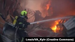 Рятувальники гасять вогонь після російського удару по Києву, 6 квітня 2025 року