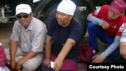 "Өзенмұнайгаз" компаниясының бұрынғы мұнайшысы, қоғамдық белсенді Роза Төлетаева (ортада) ереуілде отыр. Жаңаөзен, маусым. 2011 жыл. (Фото "Голос республики" газетінен алынды).