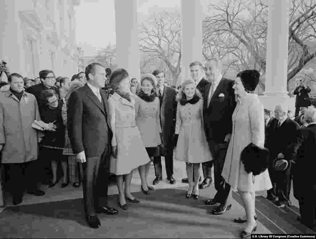 Новы прэзыдэнт Рычард Ніксан (зьлева) і ягоная сям&#39;я вітаюць сям&#39;ю папярэдняга прэзыдэнта Джонсана 20 студзеня 1969 году. Ніксана выбіралі ў Белы дом двойчы, але на сярэдзіне другой кадэнцыі ён пайшоў у адстаўку пасьля Ўотэргейтскага скандалу.