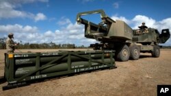 Əsgərlər HIMARS sistemlərinə ATACMS raketləri yükləyirlər