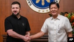 Ukrainian President Volodymyr Zelenskiy (left) shakes hands with Filipino President Ferdinand Marcos in Manila on June 3.