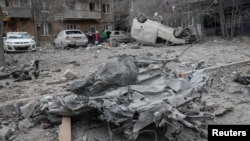 Apartment buildings and cars damaged during a Russian missile strike on Kharkiv on December 8.