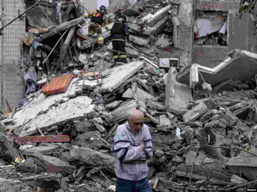 یکی از ساکنان آپارتمانی در شهر خط مقدم کوستیانتینیوکا در منطقهٔ دونتسک اوکراین که روز هفتم مه در اثر حمله هوایی روسیه به شدت آسیب دید، در حالی که امدادگران تلاش می‌کنند مادرش را پیدا کنند