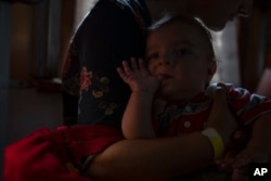 Дівчина з немовлям залишає Покровськ на евакуаційному потязі, 6 липня 2022