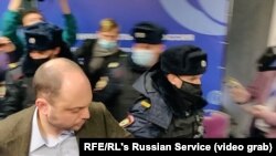 Москва полициясы көз карандысыз муниципалдык депутаттардын шеринесине чабуул койду. Алдыдагы киши -- оппозициялык саясатчы Владимир Кара-Мурза. 2021-жылдын 13-марты.