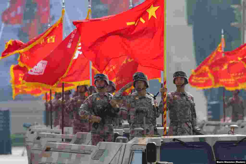 Китайські військові на бойових машинах із національними прапорами, що дуже нагадують прапори СРСР