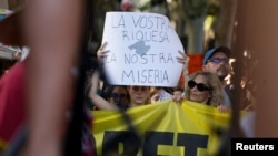 "Вашето богатство, нашата мизерия", пише на плакат в Палма де Майорка.