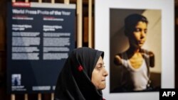 سمر ابو العوف، برندۀ جایزۀ ورلد پرس فوتو ۲۰۲۵، در کنار عکس برندۀ جایزه