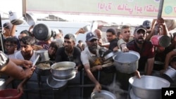 Айт майрамынын алдында тамак үчүн кезекке турган палестиндер. Хан-Юнис шаары. 15-июнь, 2024-жыл. 