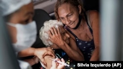  Женщина получает прививку китайской вакцины Sinovac CoronaVac в центре вакцинации  в Рио-де-Жанейро, Бразилия 2021. 