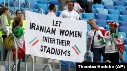 جمعی از طرفداران تیم ملی فوتبال ایران که پلاکارد «به زنان ایران اجازه حضور در استادیوم‌ها را بدهید» در دست دارند.