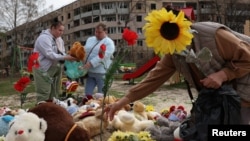 Люди несуть іграшки і квіти на дитячий майданчик після російського удару по Кривому Рогу, 5 квітня 2025 року