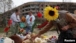 Люди несуть іграшки і квіти на дитячий майданчик після російського удару по Кривому Рогу, 5 квітня 2025 року