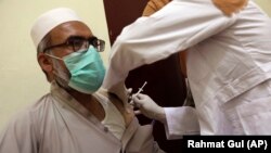 A man receives the Indian version of the AstraZeneca coronavirus vaccine from health officials at a hospital in Kabul.
