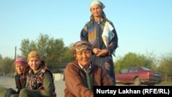 Женщины-оралманки на обочине дороги ждут случайного работодателя. Город Талгар, Алматинская область.  