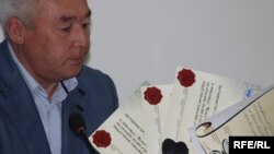 Сейтказы Матаев, председатель Союза журналистов, показывает дипломы, выписанные противникам свободы прессы в Казахстане. Алматы, 4 мая 2010 года.