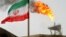 A gas flare on an oil production platform in the Soroush oil fields is seen alongside an Iranian flag in the Gulf 
