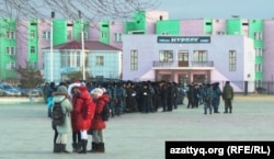 Группа девочек стоит на площади, на которой собрались полицейские. Город Жанаозен, 14 декабря 2013 года.