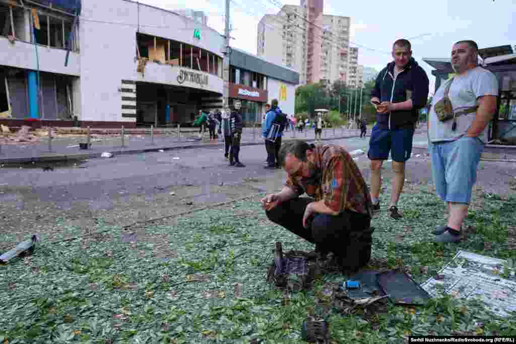 Перехожі роздивляються уламки російського дрона, який атакував Київ