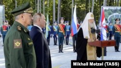 Зліва направо: міністр оборони Росії Сергій Шойгу, російський президент Володимир Путін і патріарх РПЦ Кирило під час закладення каменя в фундамент головного храму Збройних сил Росії на території військово-патріотичного парку «Патріот». Московська область, 19 вересня 2018 року