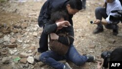 Женщина пытается защитить свой дом от сноса. Китай, провинция Гуандун, март 2012 года. Иллюстративное фото.  