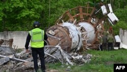 Un anchetator al poliției ucrainene examinează turnul de televiziune din Harkov, după ce a fost doborât de un atac rusesc cu rachete - 22 aprilie 2024.