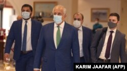U.S. special envoy for Afghanistan Zalmay Khalilzad (second left) arrives at a hotel in Qatar's capital, Doha, for an international meeting on the escalating conflict in Afghanistan on August 10.