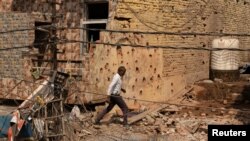Мъж се разхожда сред отломки на покрива на повредена къща след военната операция на Пакистан срещу Индия в Рехари, Джаму, 10 май 2025 г.
