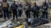 Police officers stand next to the bodies of people found under the debris of an apartment building that was hit by a Russian air strike in Kharkiv on October 31.